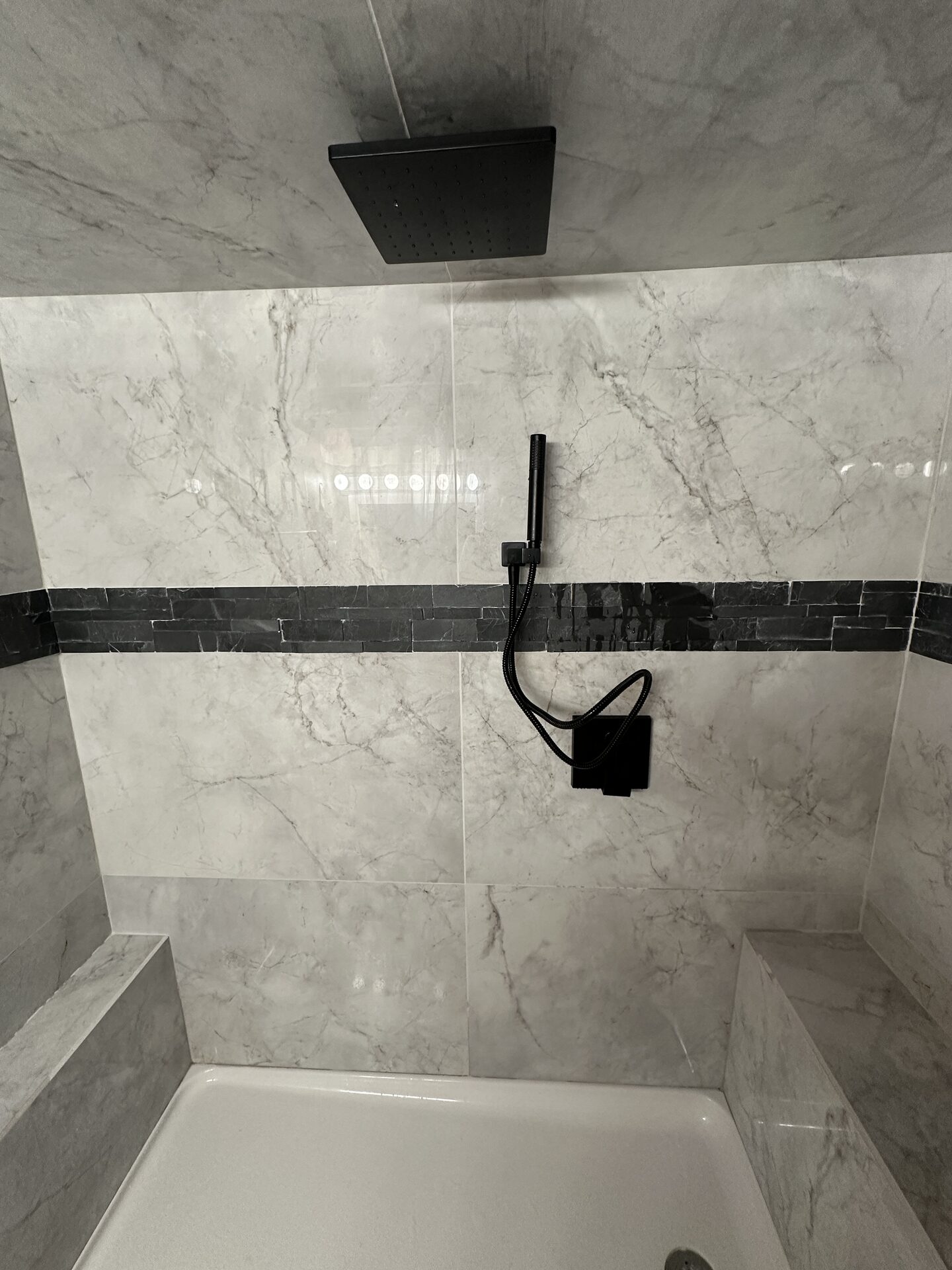 Finished bathroom with onyx-look marble shower and freestanding tub
